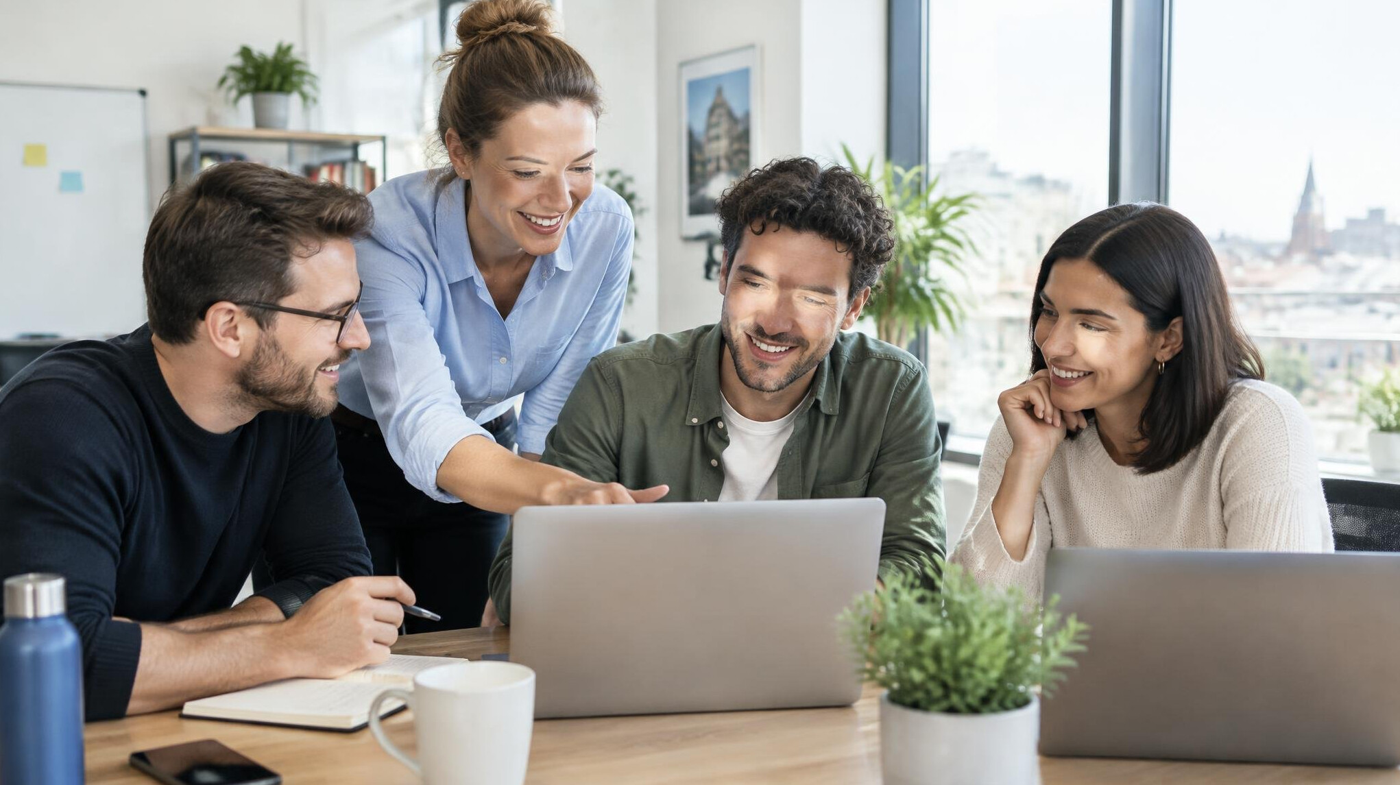 Team of colleagues working together around laptops in a modern office